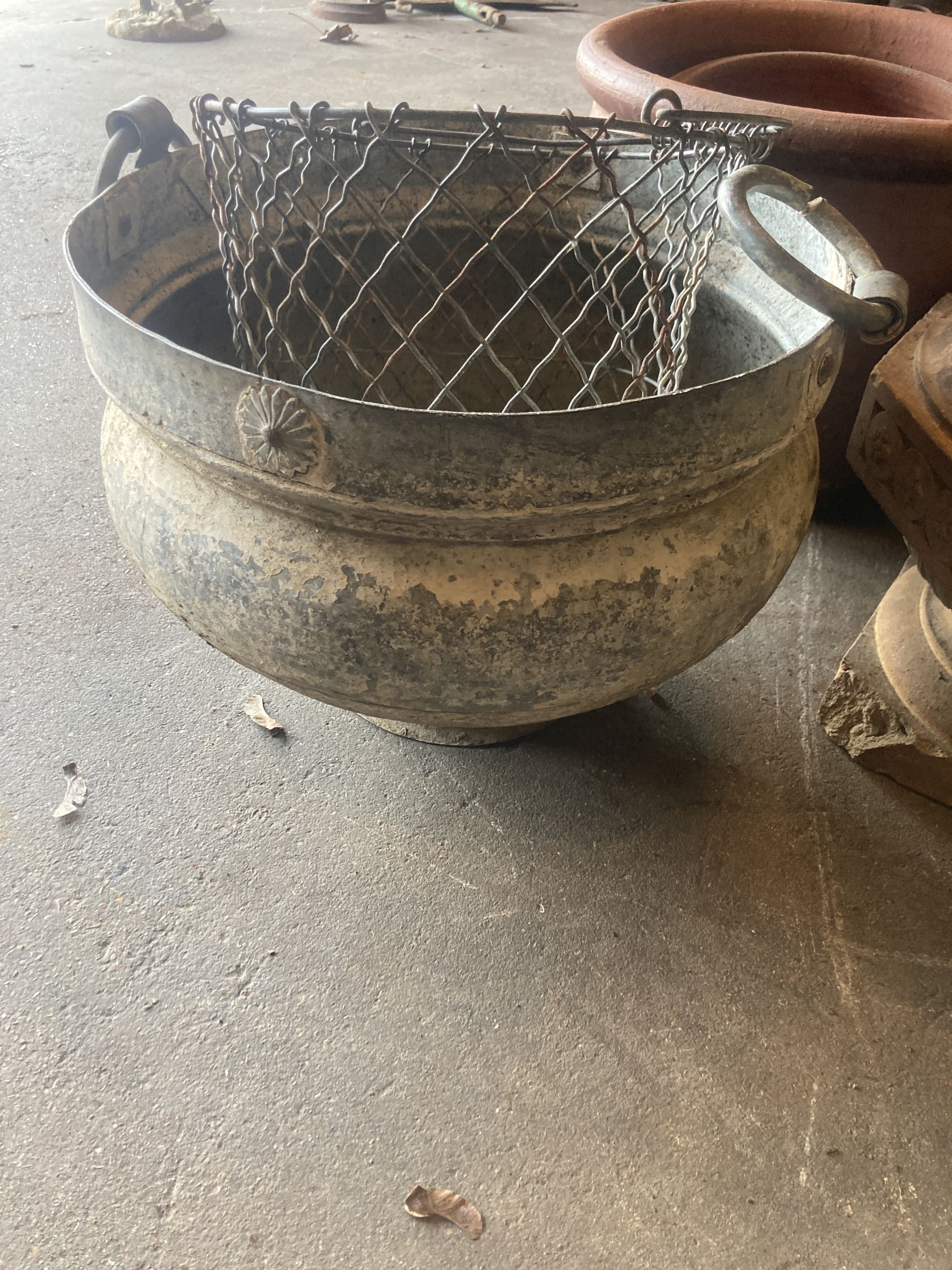 A quantity of assorted terracotta, glazed earthenware and metal garden planters together with a wirework basket, largest 40cm diameter